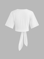 White cotton crop top with short sleeves, crew neck, and wide knotted back tie.