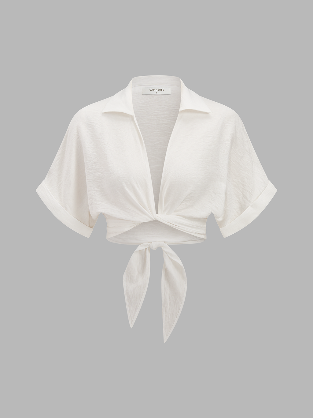 White short-sleeve collared knotted crop top paired with coordinated patterned high-waisted pants.