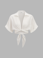 White short-sleeve collared knotted crop top paired with coordinated patterned high-waisted pants.