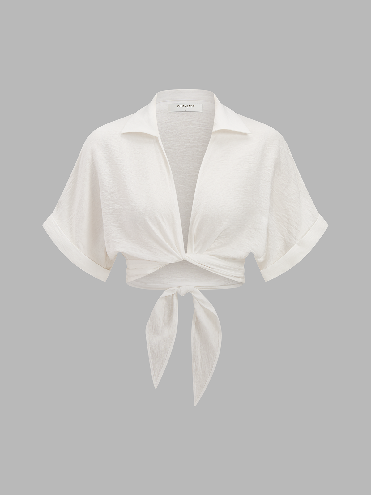 White short-sleeve collared knotted crop top paired with coordinated patterned high-waisted pants.