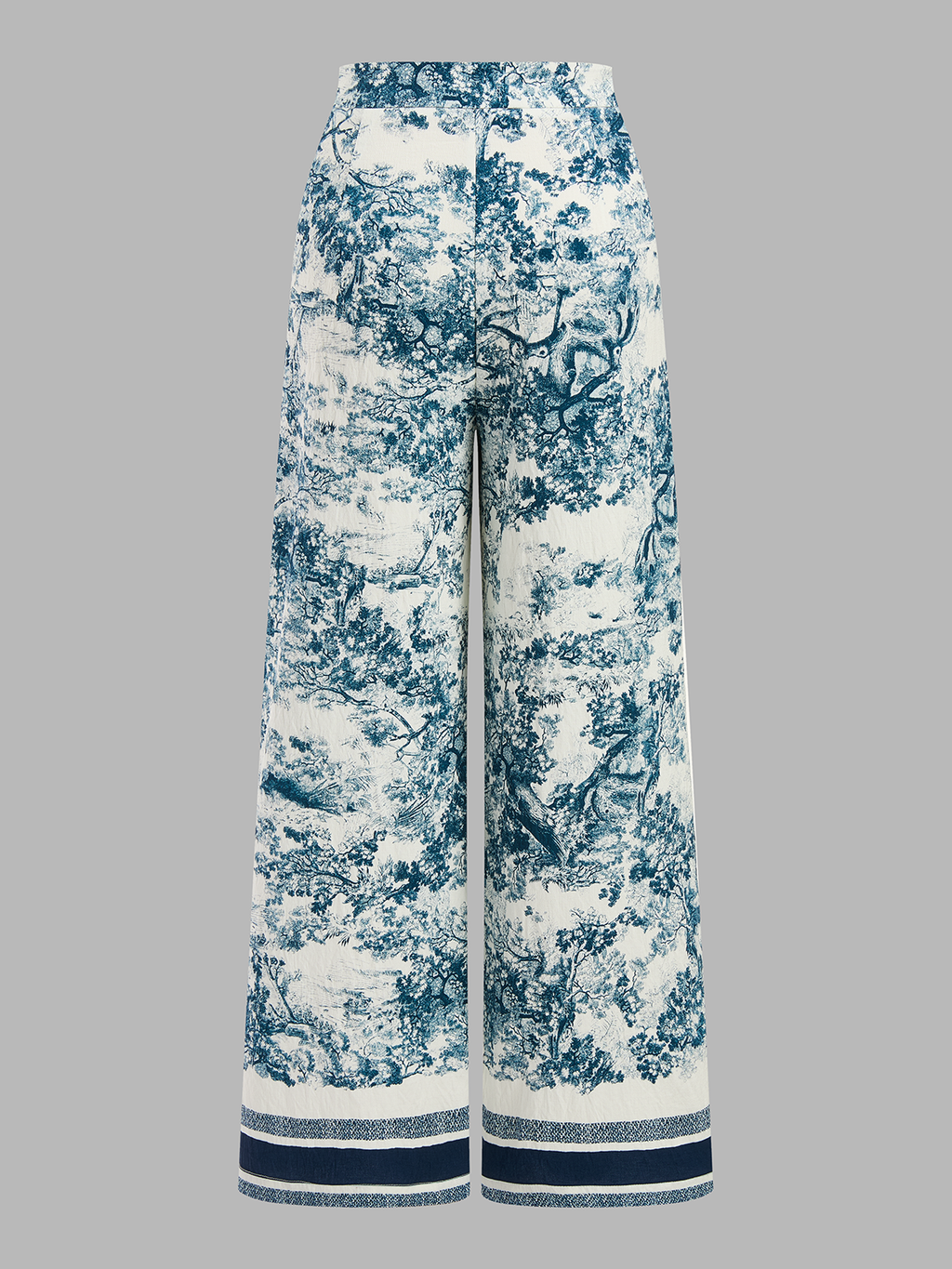 Knotted crop top and wide-leg, high-waisted patterned pants with blue pastoral print and stripes.