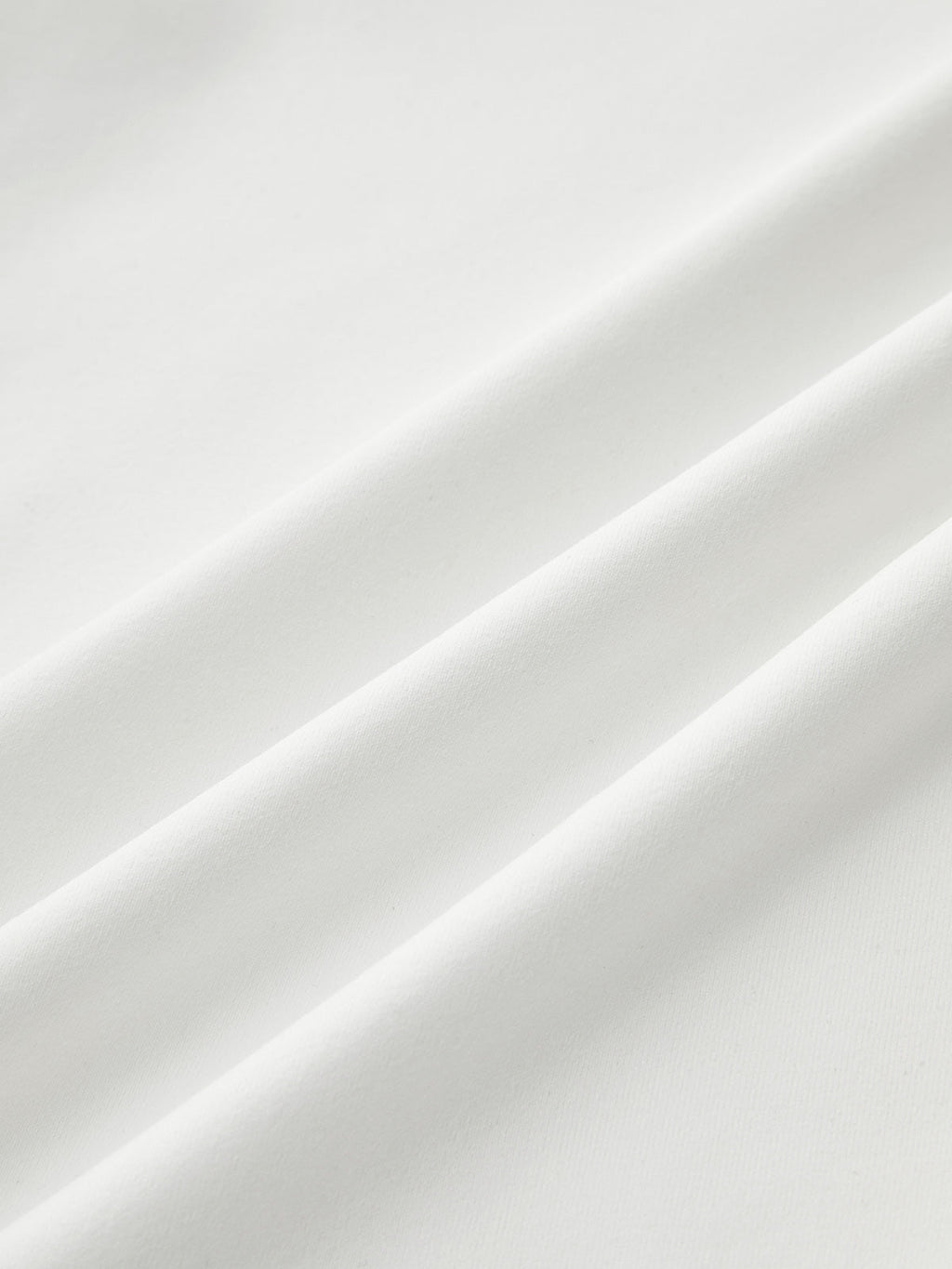 Mock neck sleeveless top in smooth white fabric with ruched detail and soft diagonal folds.