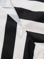 Partially unzipped white zipper on a striped halter maxi dress with visible stitching.