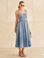 LA FINE FLEUR denim midi dress with tie straps and tiered design.