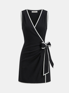 Black linen-blend mini wrap dress with contrast trim, V-neckline, sleeveless, and side waist bow.