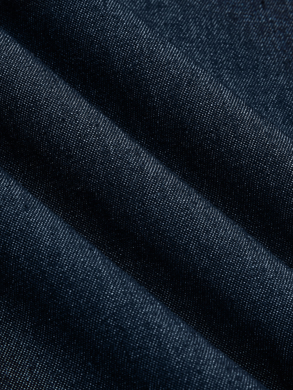 Sleeveless, flared dark blue denim midi dress with visible diagonal weave and subtle folds.