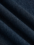 Sleeveless, flared dark blue denim midi dress with visible diagonal weave and subtle folds.