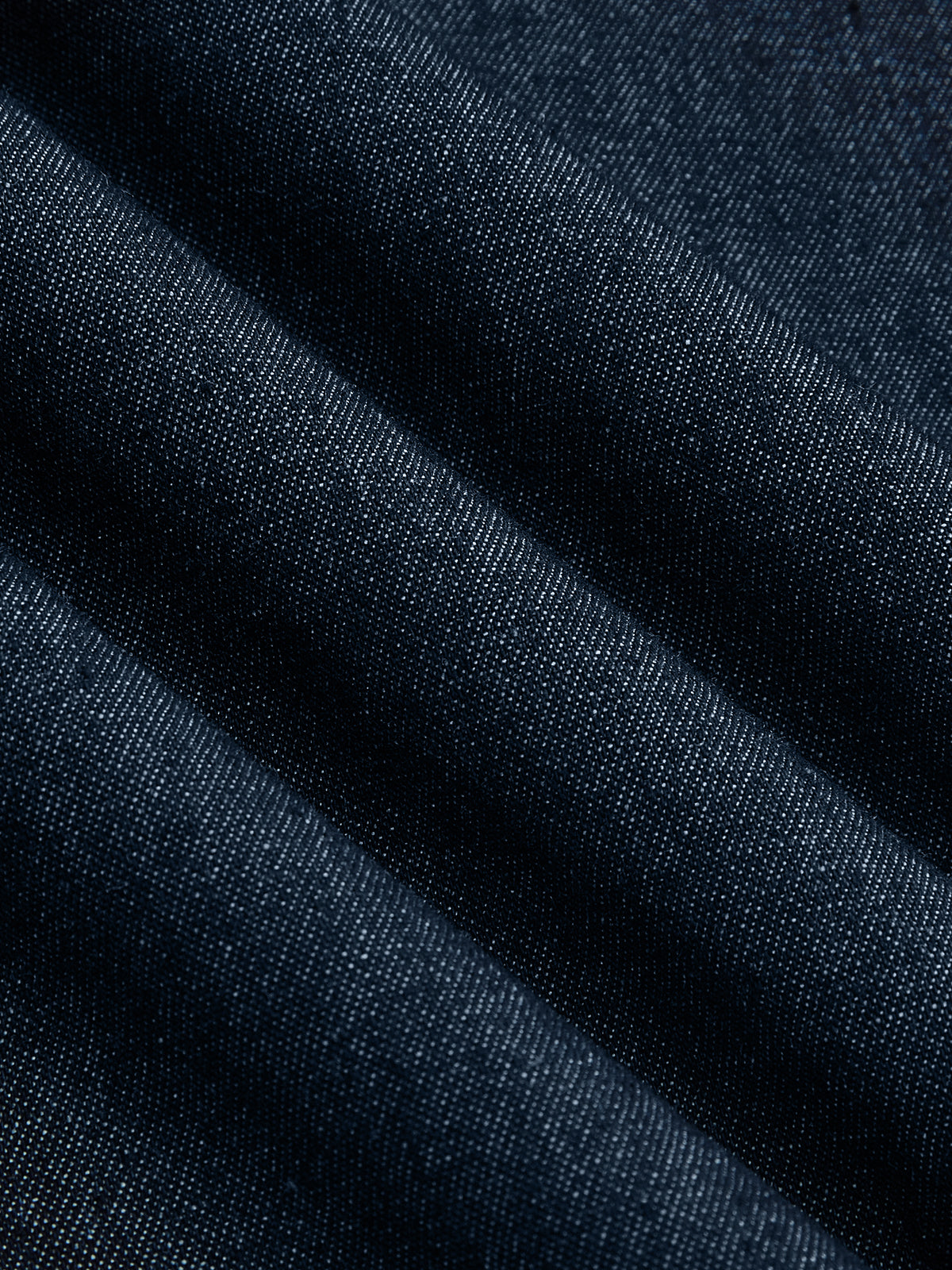 Sleeveless, flared dark blue denim midi dress with visible diagonal weave and subtle folds.