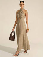 LA FINE FLEUR cotton linen maxi dress featuring a halter neck and front cut-out.