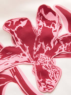 Strapless mini dress with three-dimensional pink and maroon floral design and stitched edges.