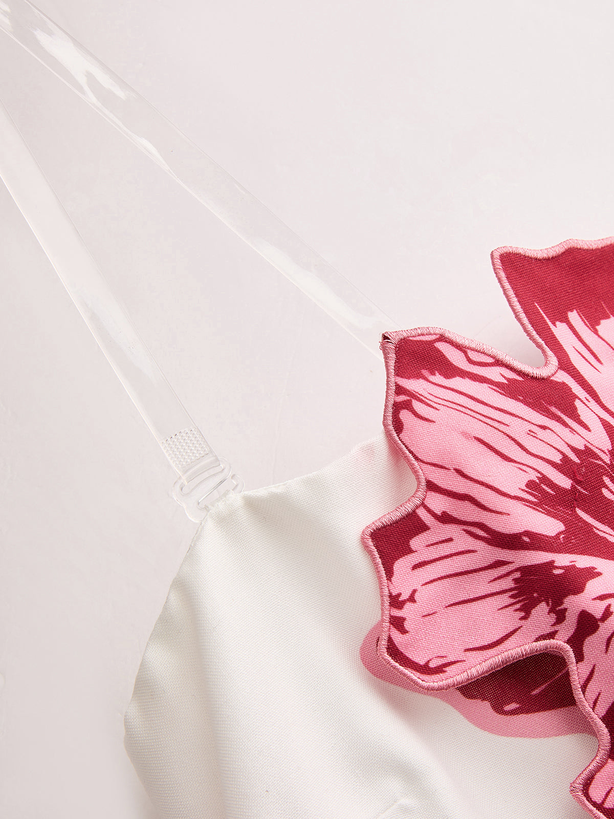 Strapless mini dress with bold three-dimensional floral design and chic, summery style.