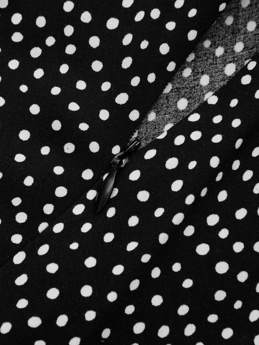 Lace V-neck midi dress with polka dot pattern, partially unzipped black zipper visible.