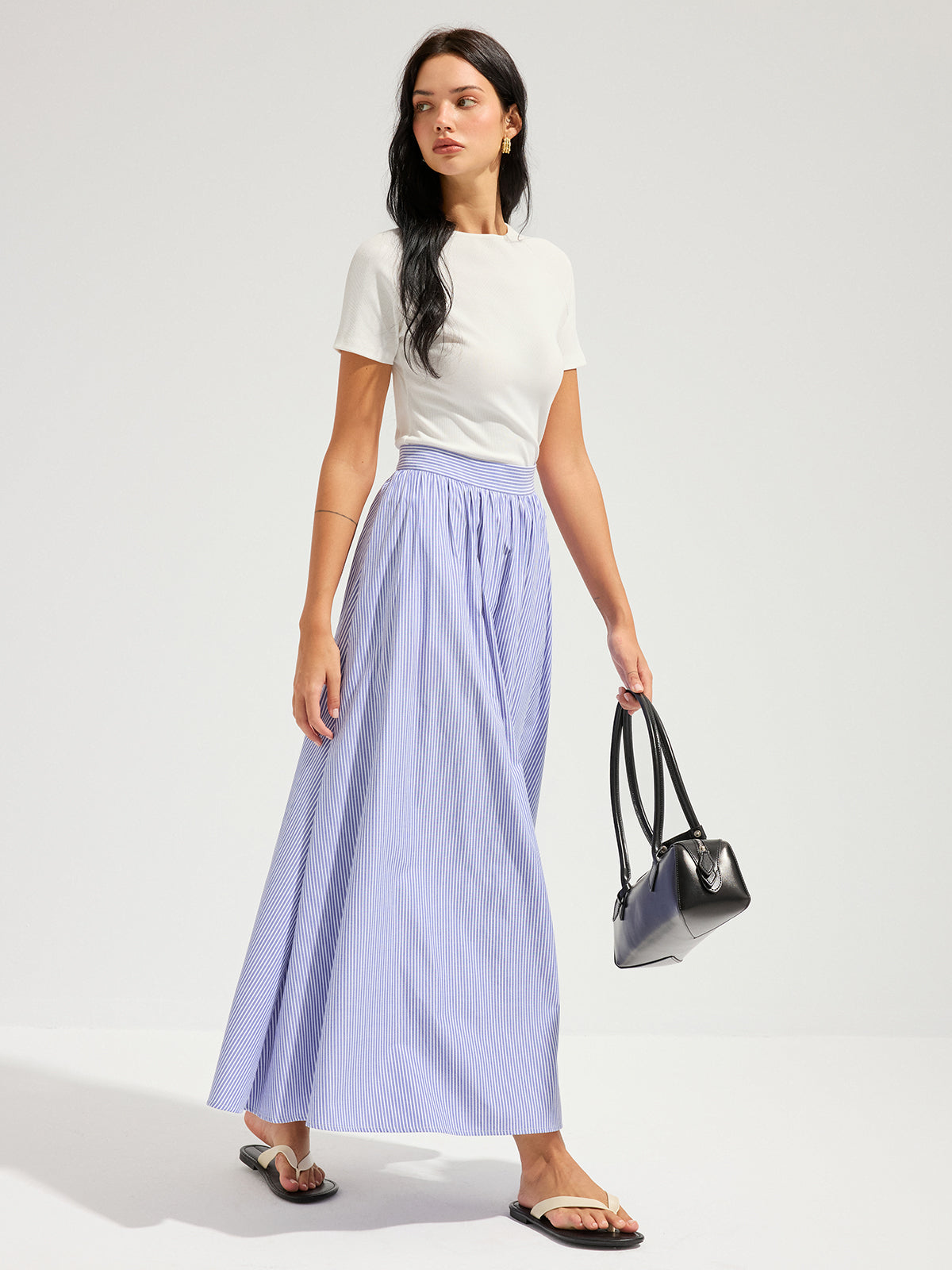 Open Back Ribbed Top with Short Sleeves paired with a long light blue pleated skirt.