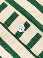 Textured woven polyester dress with cream and green stripes, white button, and partial buttonhole.