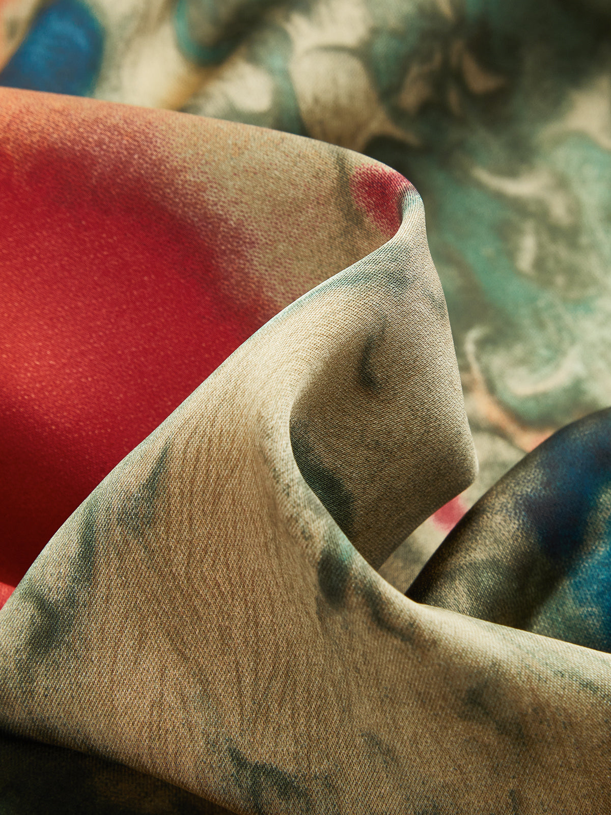 Soft, silky cami mini dress with ruched drawstring and colorful abstract red, beige, teal, blue patterns.