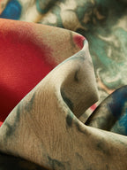 A ruched cami mini dress with abstract red, green, blue, and beige watercolor-like pattern.