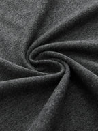 Sleeveless dark gray ruched dress with belted, asymmetrical hem and twisted, soft-textured fabric.