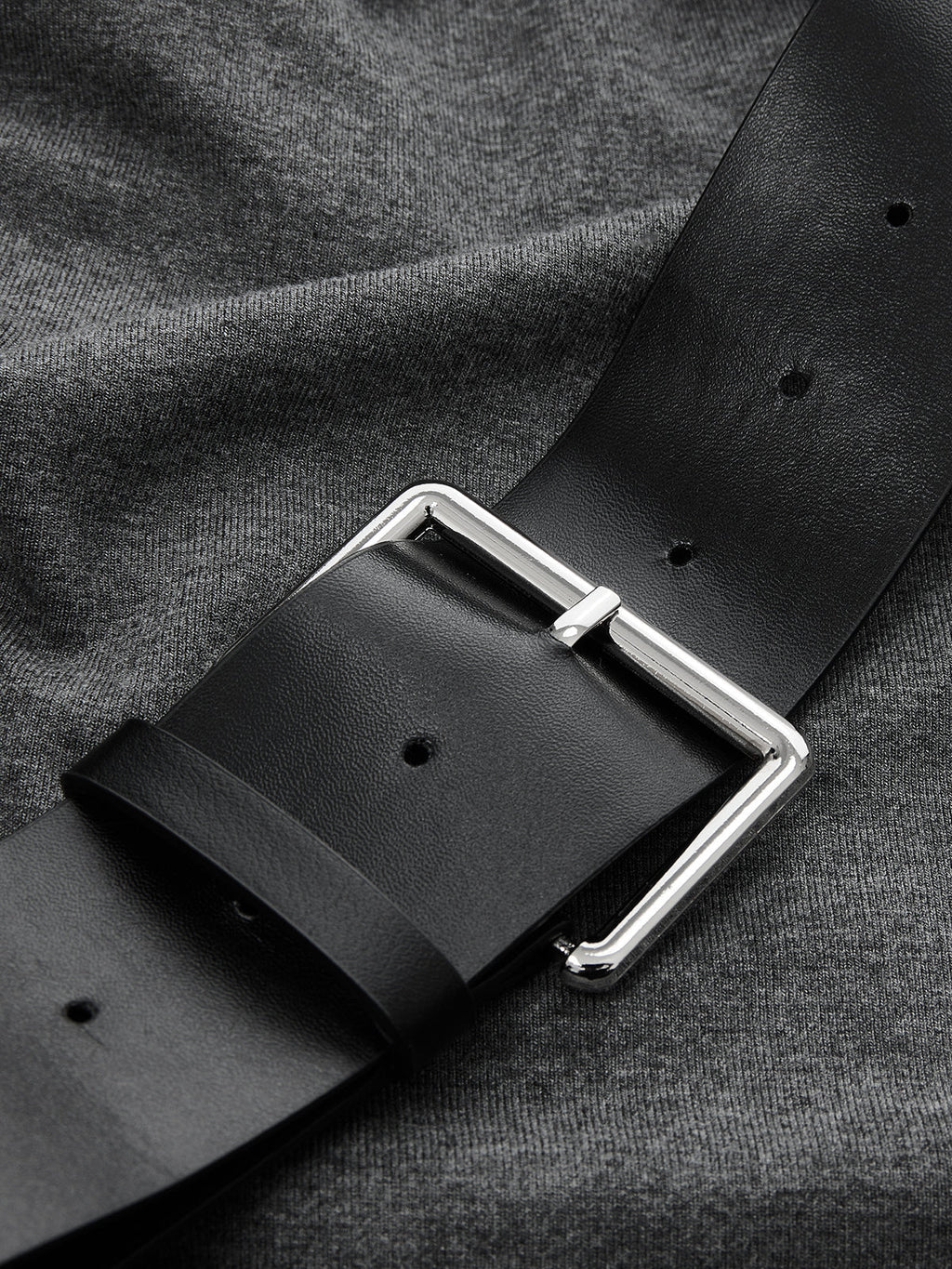Sleeveless ruched dress with asymmetrical hem and a black belt with silver buckle.