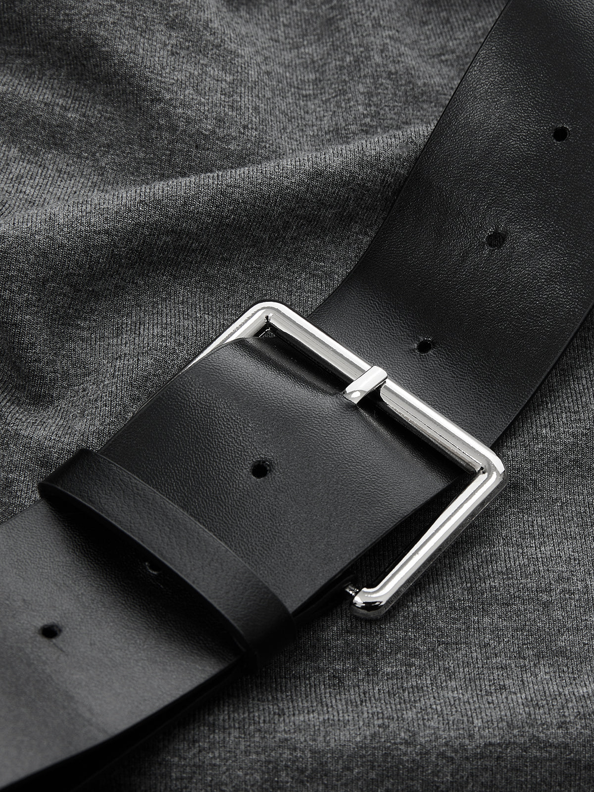 Sleeveless ruched dress with asymmetrical hem and a black belt with silver buckle.