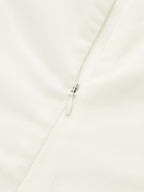 Strapless white maxi dress featuring elegant ruching and a flowy, formal silhouette.