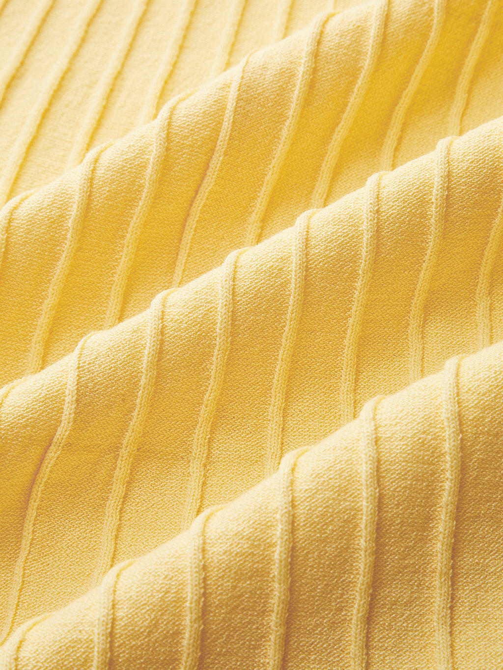 Yellow ribbed dress with vertical lines and soft, wavy folds in the fabric texture.