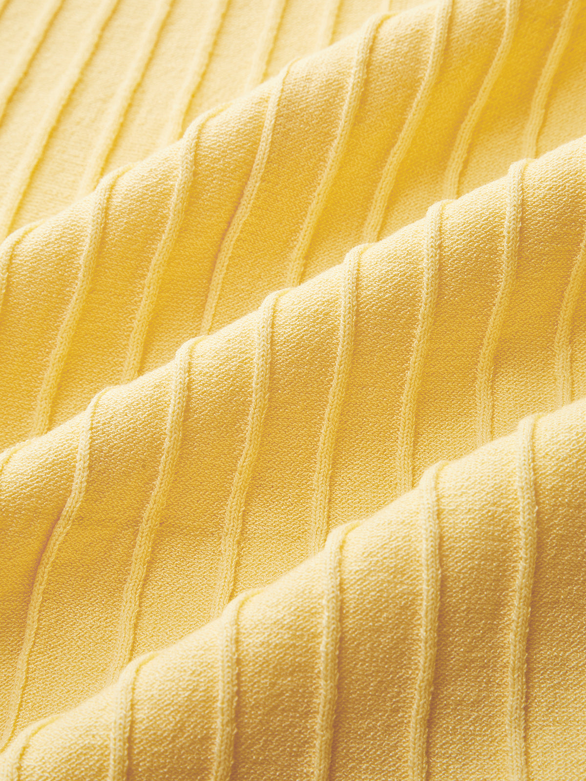 Yellow ribbed dress with vertical lines and soft, wavy folds in the fabric texture.