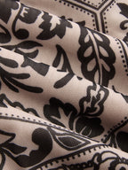 Flowy sleeveless maxi dress with camisole top, beige mesh and ornate black floral pattern.