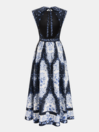 A navy and white floral maxi dress with open back, sleeveless cut, and tie-neck.