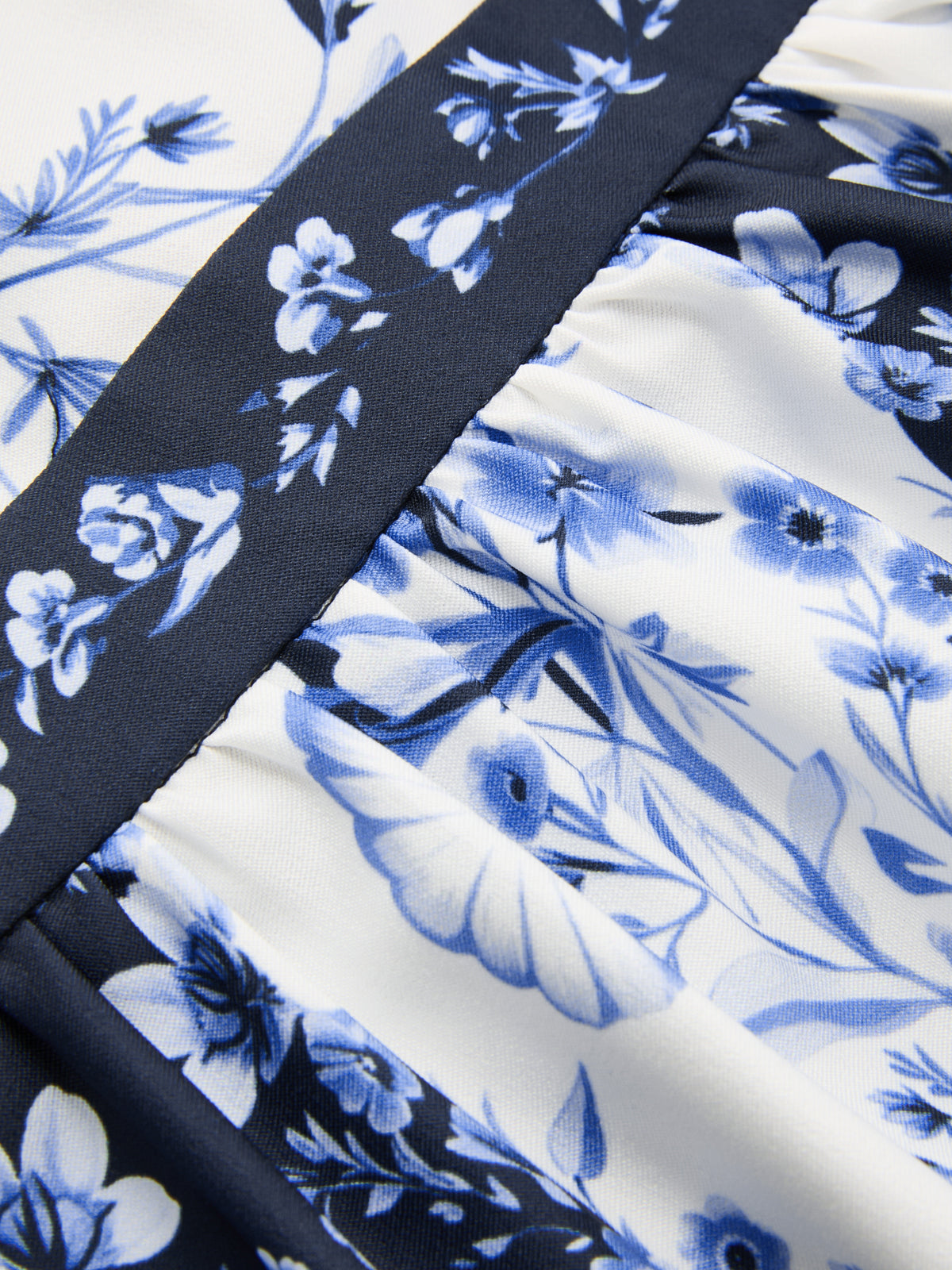 Blue and white floral backless maxi dress with gathered seams and a dark blue floral strip.