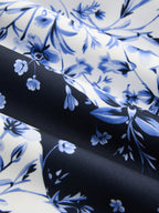 Blue and white floral-patterned maxi dress with soft, shadowed folds and intricate detailing.