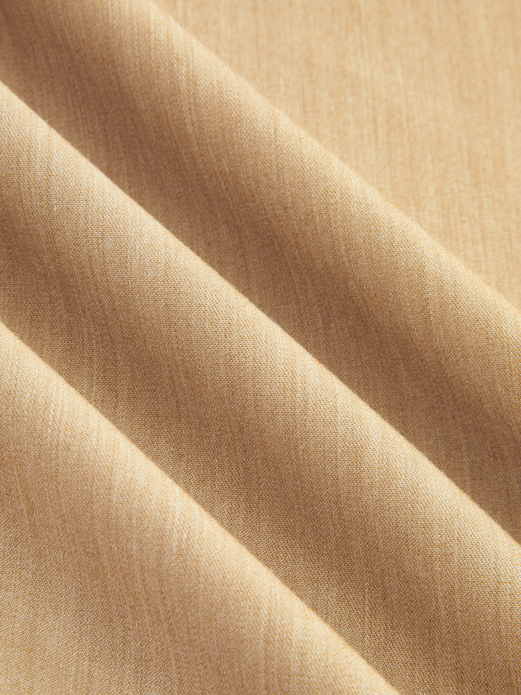 Close-up of beige LA FINE FLEUR halter maxi dress fabric with soft diagonal folds.