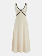 Sleeveless maxi dress with V-neck, fitted bodice, black wavy trim on neckline and waist.