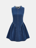 Sleeveless blue denim mini dress with open back, flared skirt, and visible seams.