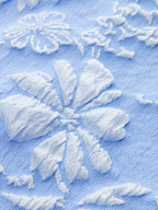 Sleeveless Jacquard mini dress in light blue with delicate white embroidered floral patterns.