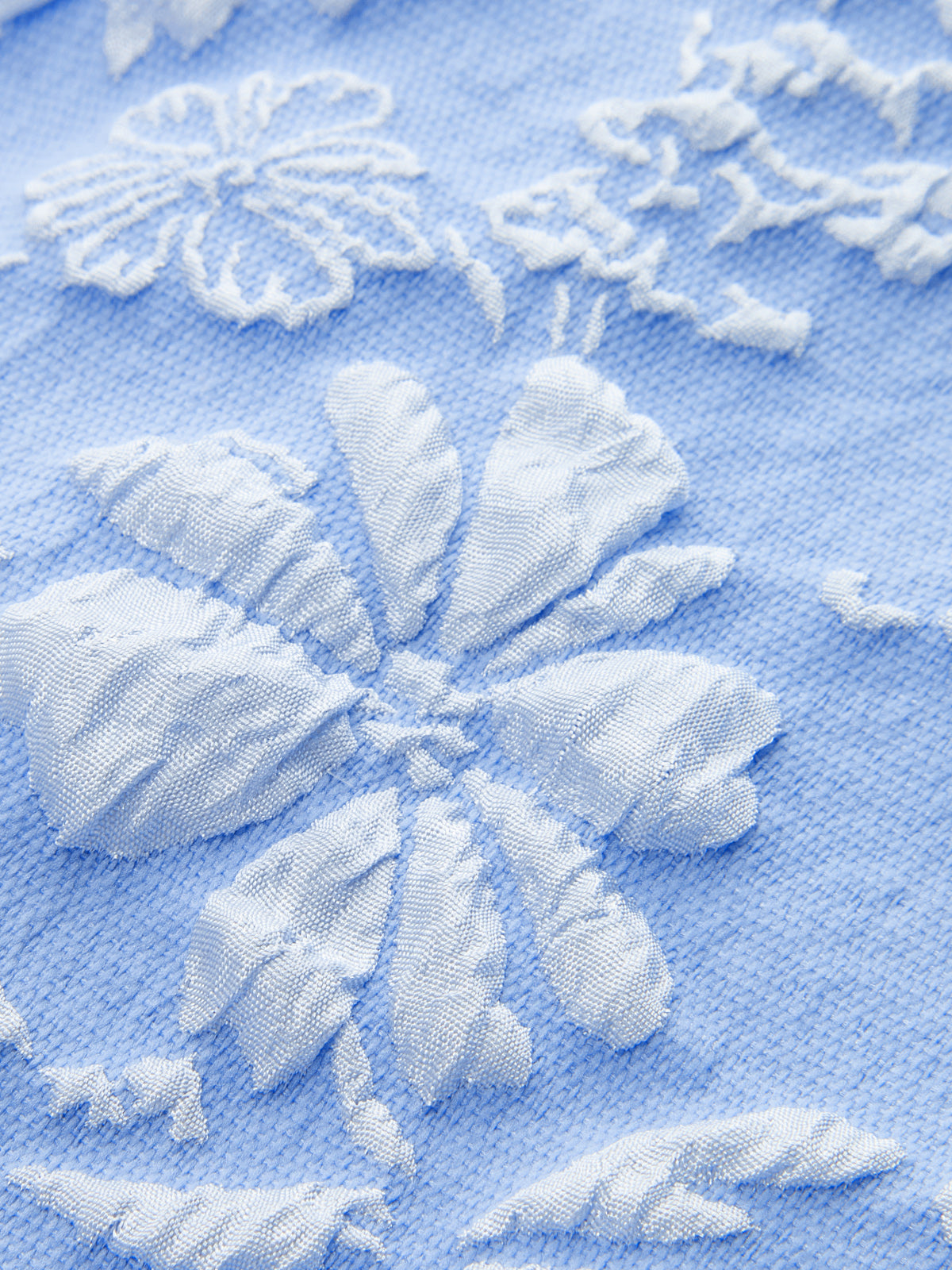 Sleeveless Jacquard mini dress in light blue with delicate white embroidered floral patterns.