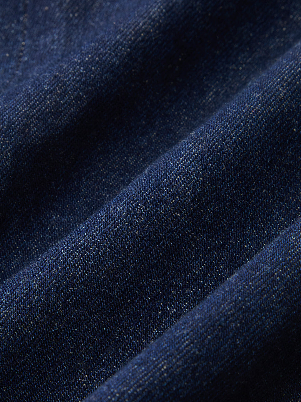 Dark blue denim romper with epaulets, natural folds, and subtle color variations visible.