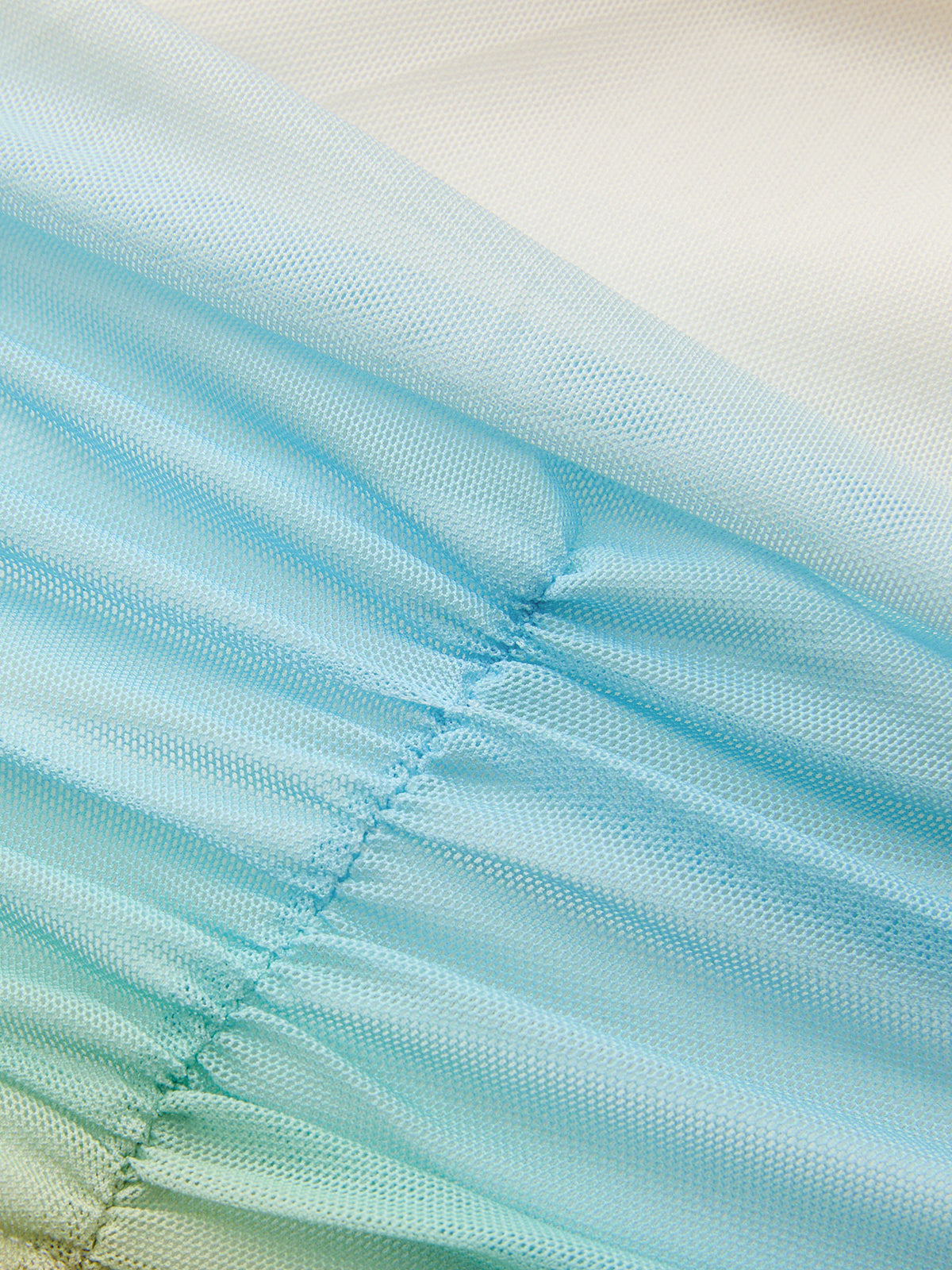 Gradient light blue and white mesh evening gown with diagonal ruching and pleated, semi-transparent textures.