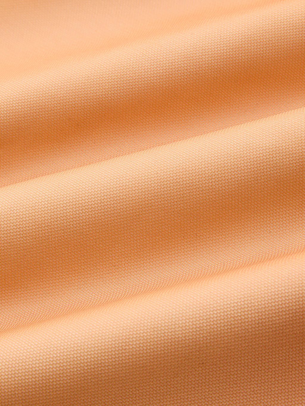 Light orange, textured woven evening gown with gentle folds and soft, flexible drape.