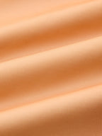 Light orange, textured woven evening gown with gentle folds and soft, flexible drape.