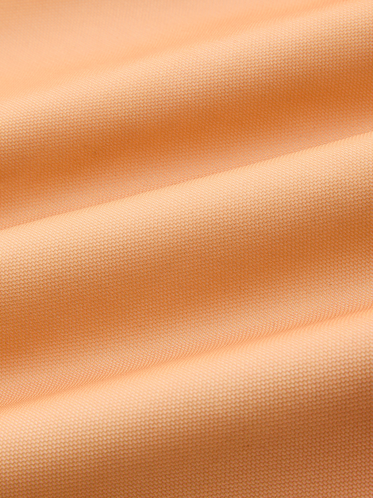 Light orange, textured woven evening gown with gentle folds and soft, flexible drape.
