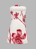 Strapless mini dress with a fitted bodice and flared skirt, featuring 3D floral details.