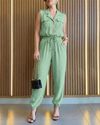 Sleeveless notched collar jumpsuit with drawstring waist and flap pockets in a tailored style.